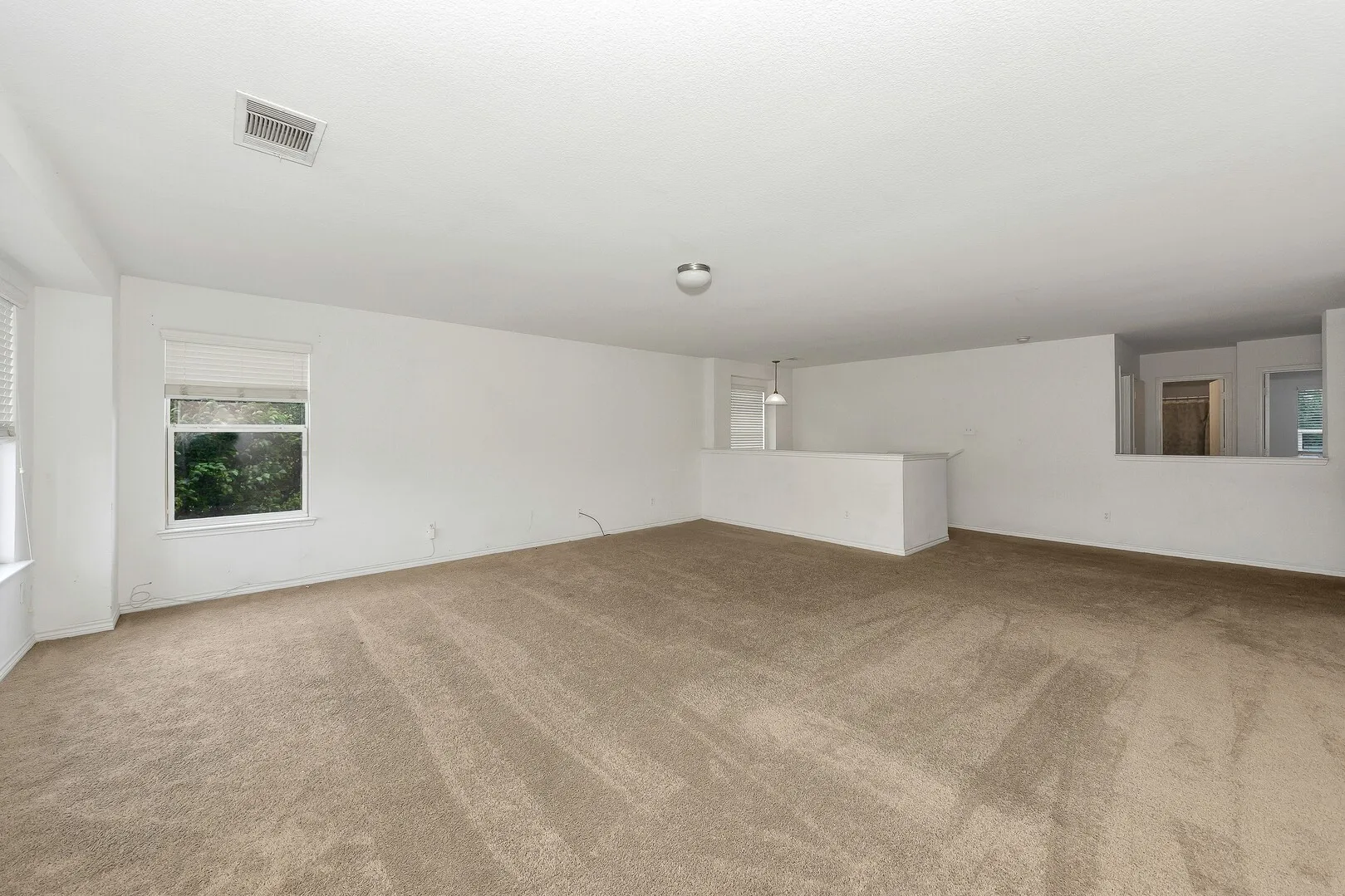 Carpeted spare room featuring baseboards