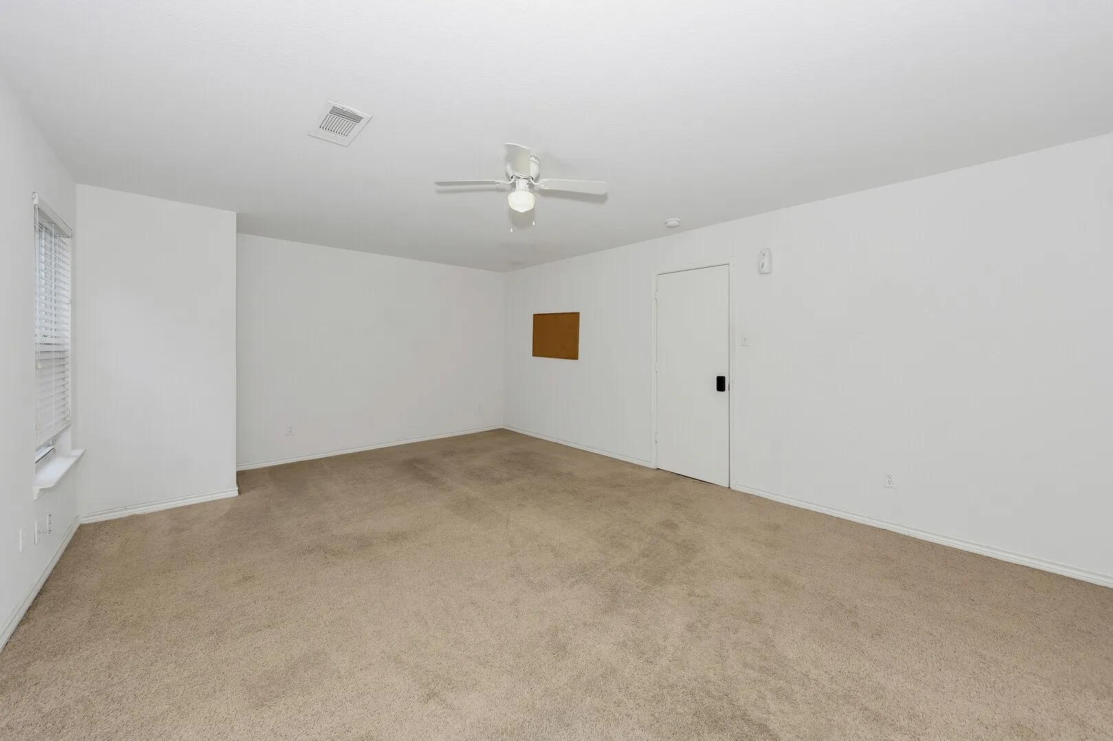 Spare room featuring ceiling fan, light colored carpet, and baseboards