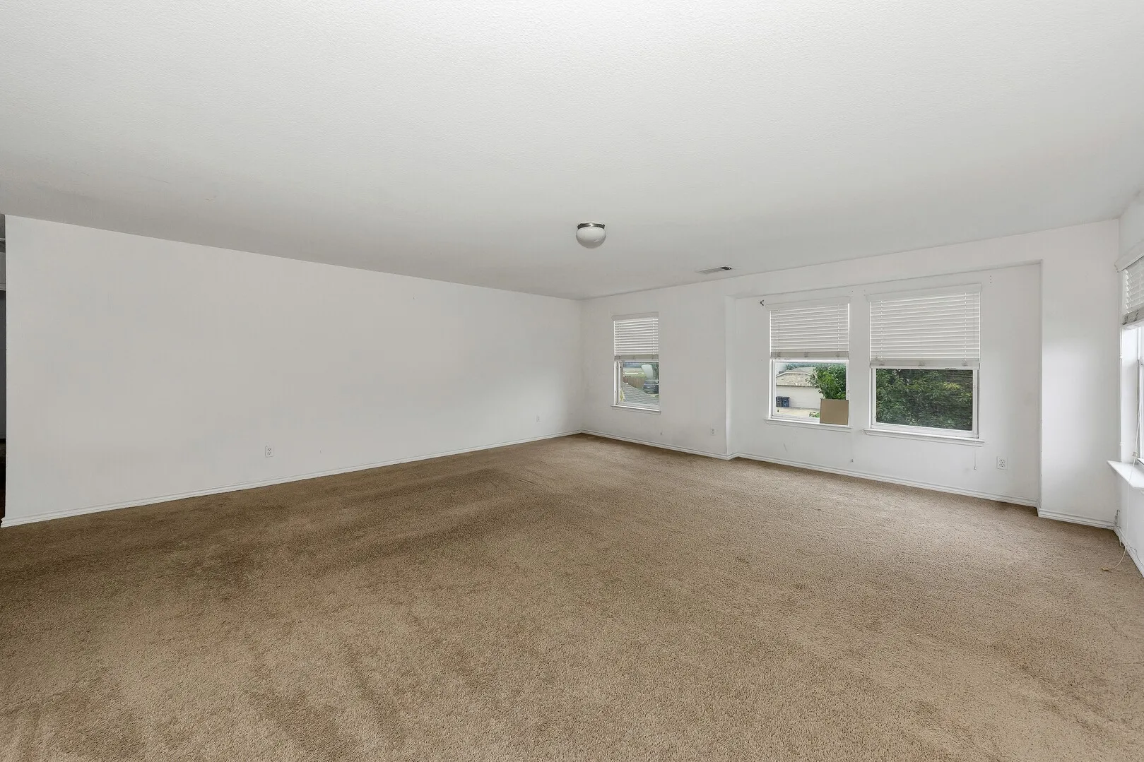 Carpeted spare room featuring baseboards