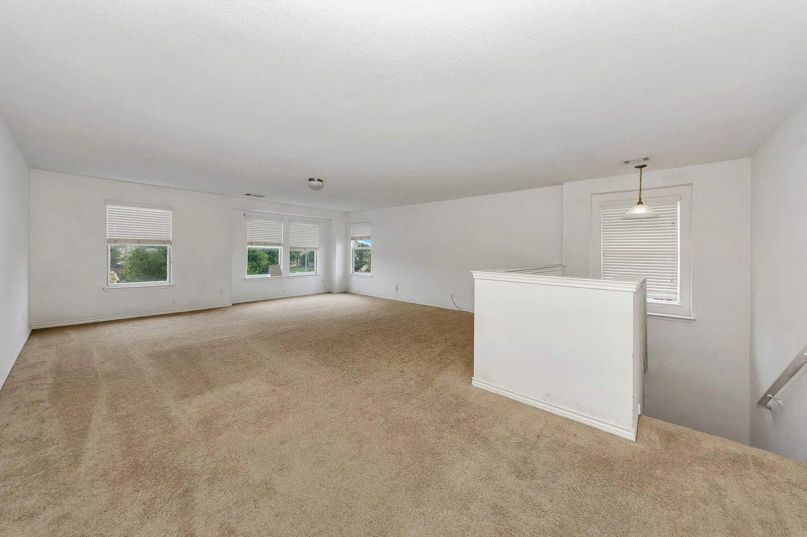 Empty room with carpet flooring and healthy amount of natural light