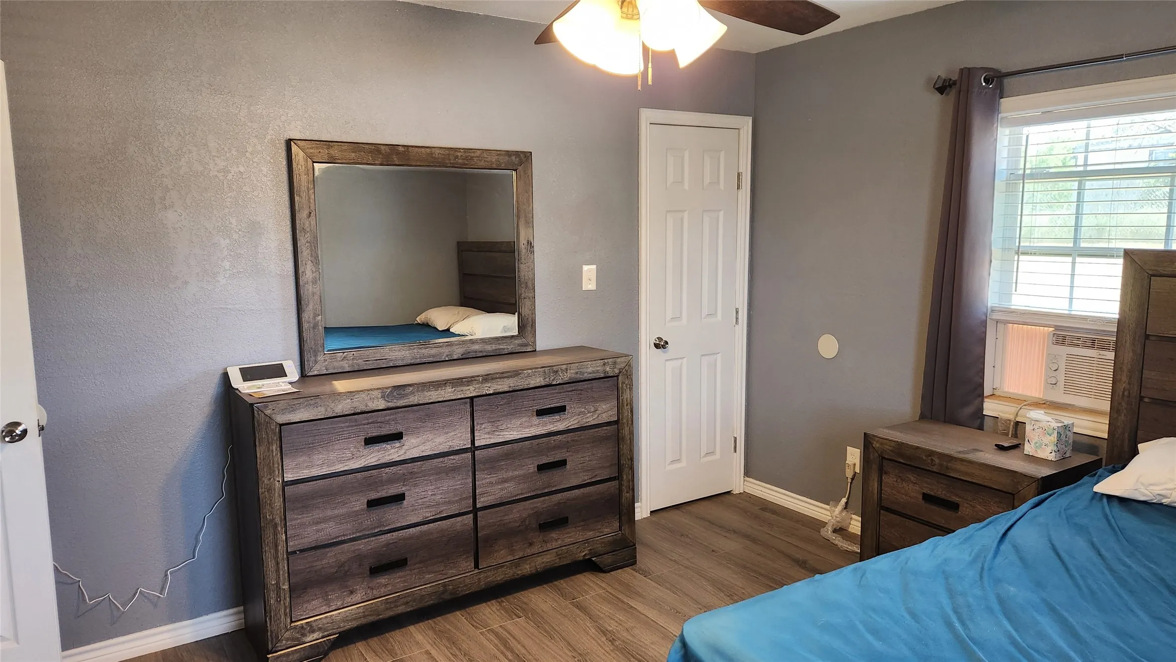 Bedroom with baseboards, wood finished floors, ceiling fan, and cooling unit
