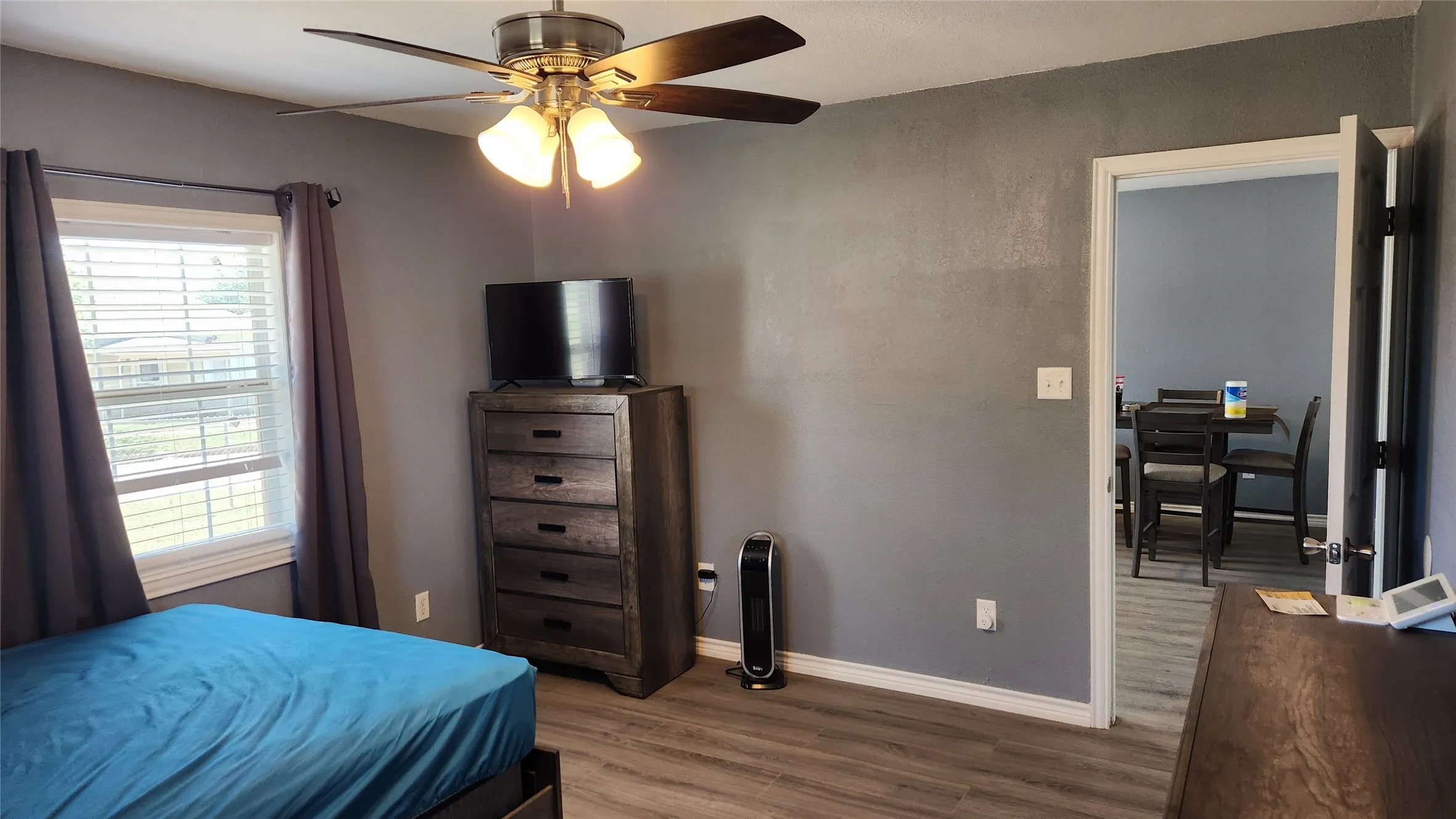 Bedroom featuring wood finished floors, baseboards, and a ceiling fan