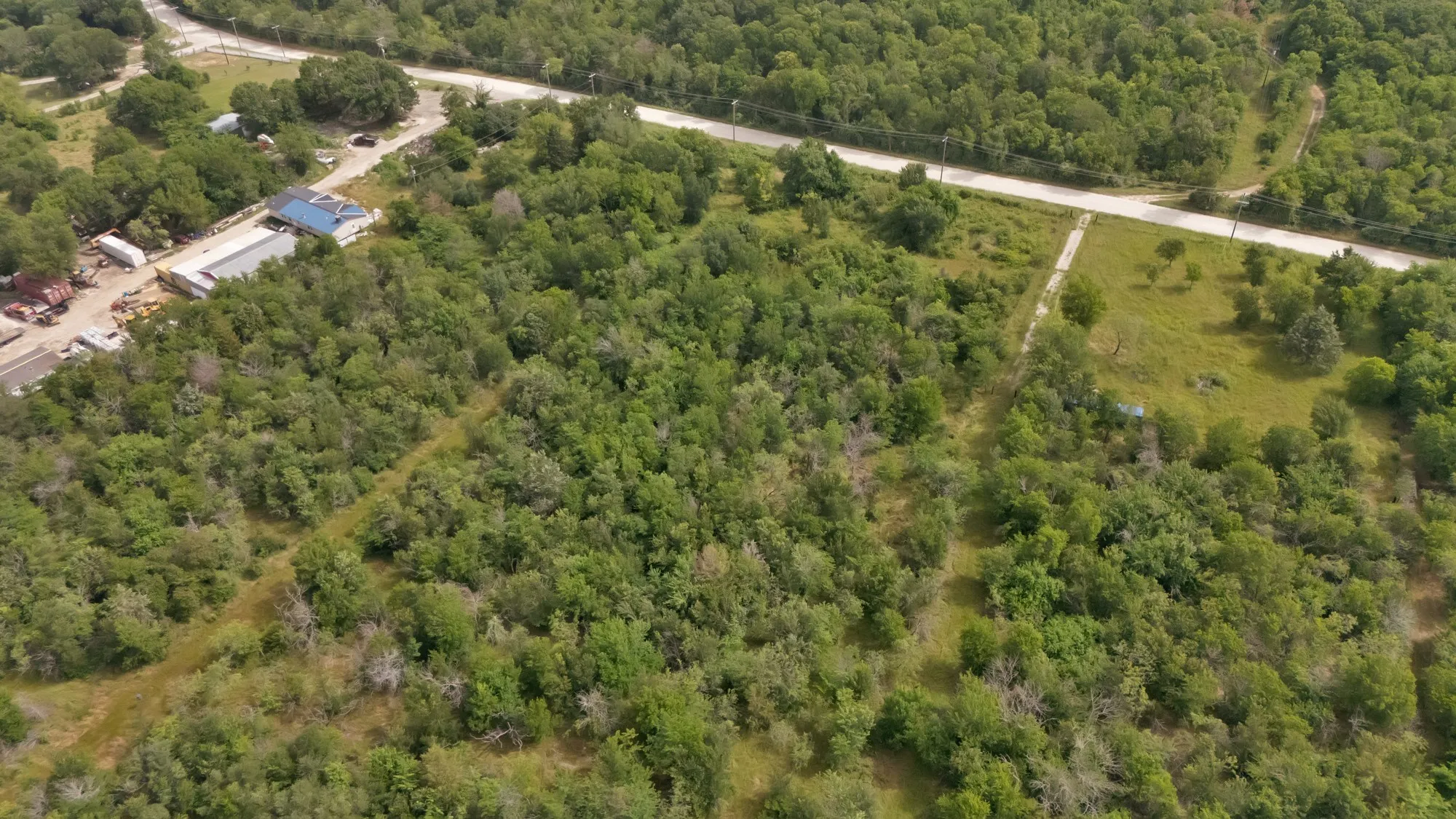 Aerial view of property's location featuring a heavily wooded area