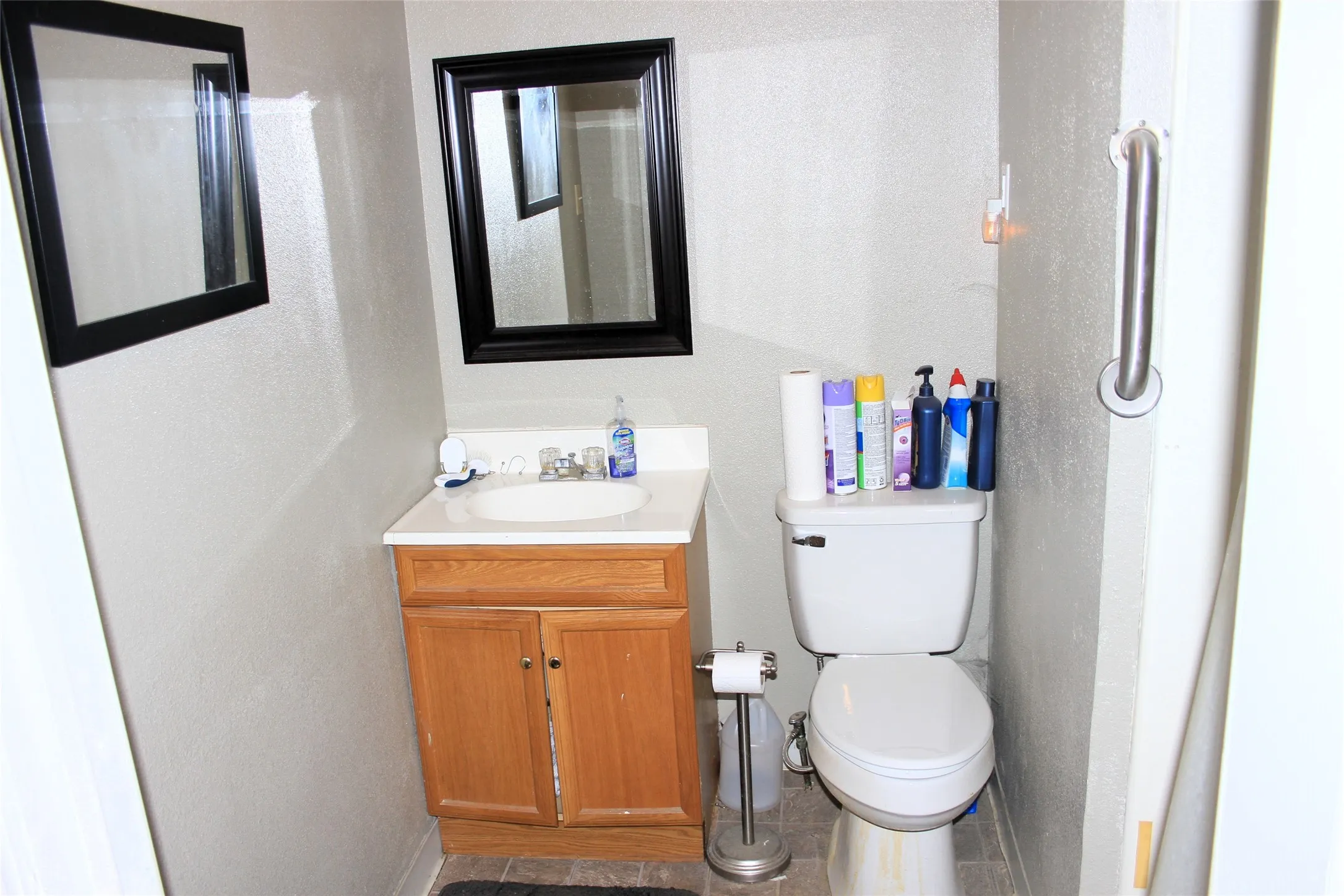 Bathroom featuring toilet, vanity, baseboards, and tile patterned floors