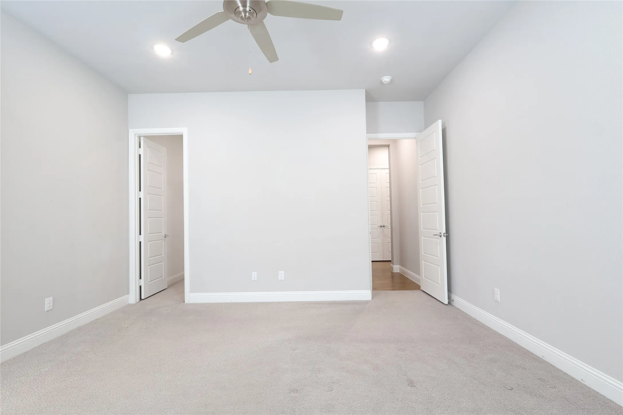 Unfurnished bedroom with light carpet, baseboards, recessed lighting, and a ceiling fan