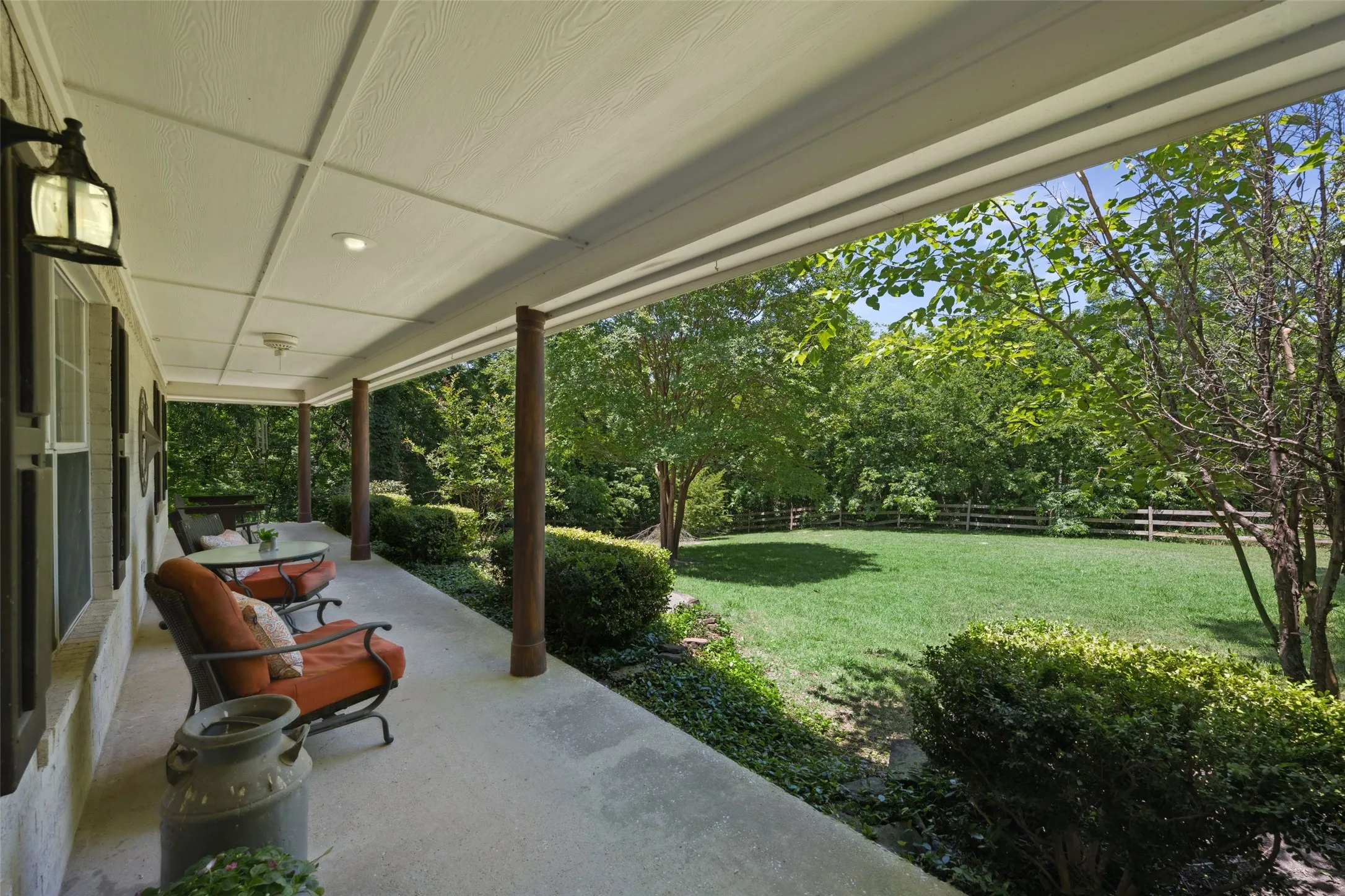 Scenic covered patio with serene views of the tree-lined property—ideal for relaxing, coffee, or enjoying the peaceful outdoors.
