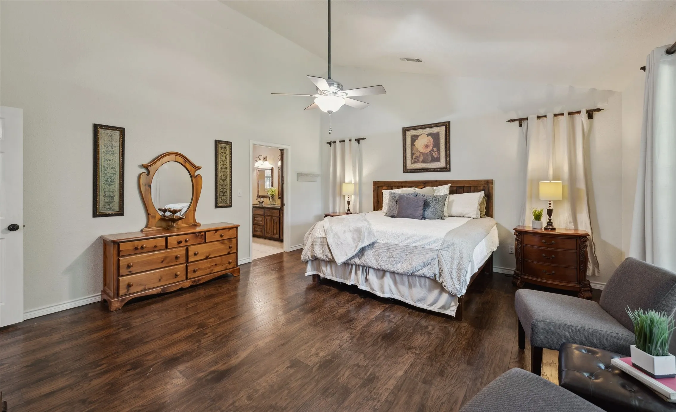 Oversized primary suite with rich wood flooring, tranquil views, and plenty of space to unwind or add a cozy sitting area