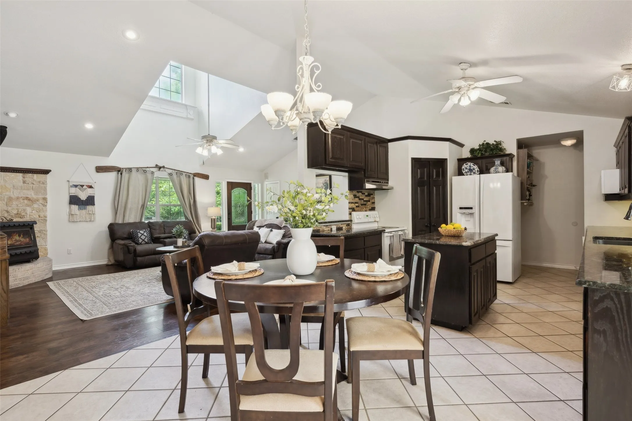 Charming kitchen with rich cabinetry, granite countertops, and a cozy breakfast nook—brightened by natural light and backyard views.