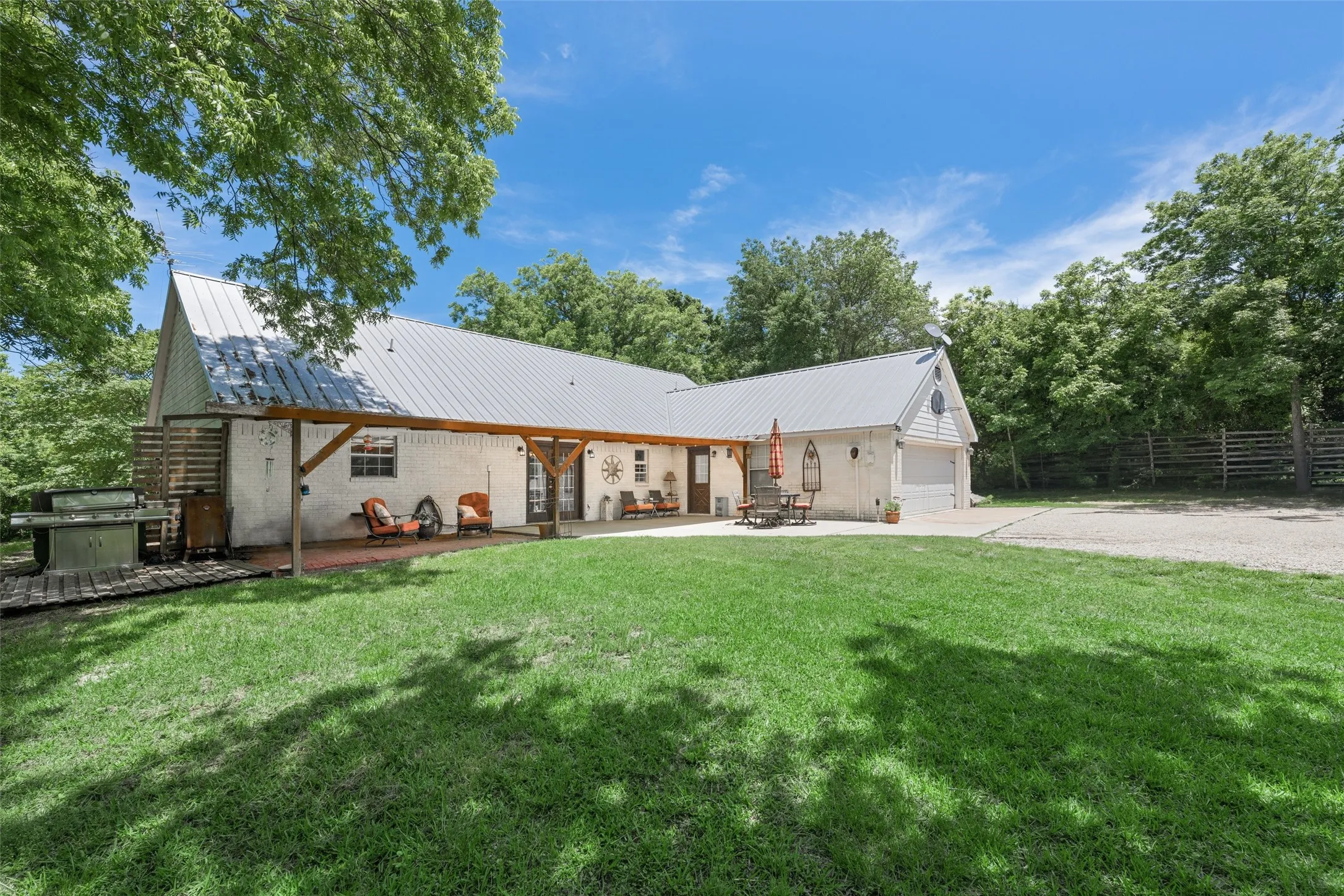 Scenic covered patio with serene views of the tree-lined property—ideal for relaxing, coffee, or enjoying the peaceful outdoors.
