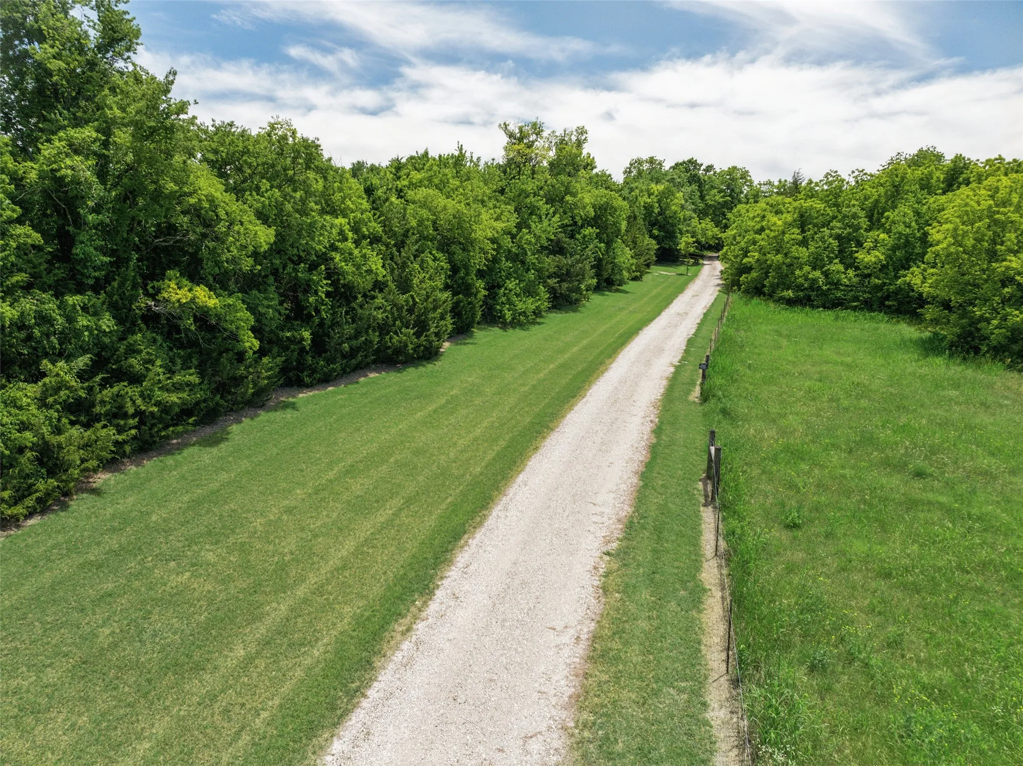 Scenic trail winds through the trees, leading to the home and the peaceful back acreage—ideal for morning walks or sunset strolls.