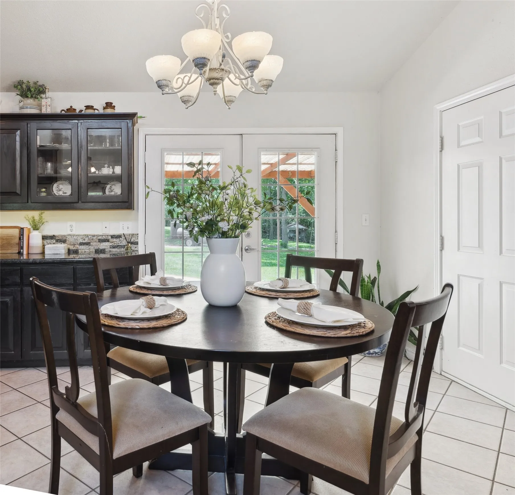 Charming kitchen with rich cabinetry, granite countertops, and a cozy breakfast nook—brightened by natural light and backyard views.