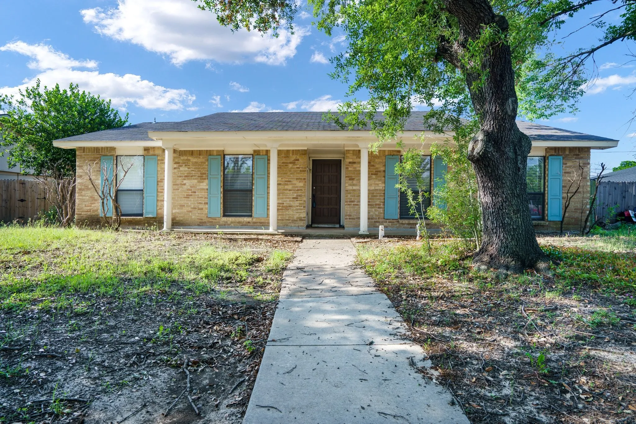 Ranch-style home with brick siding and a porch