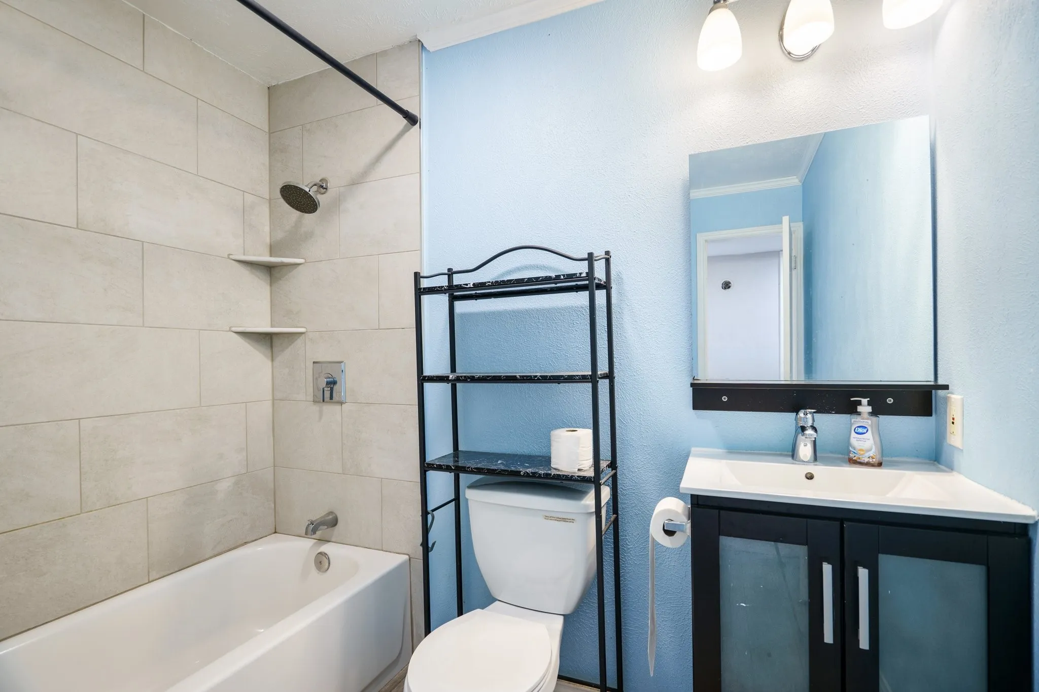 Bathroom featuring vanity, shower / bathtub combination, toilet, and ornamental molding