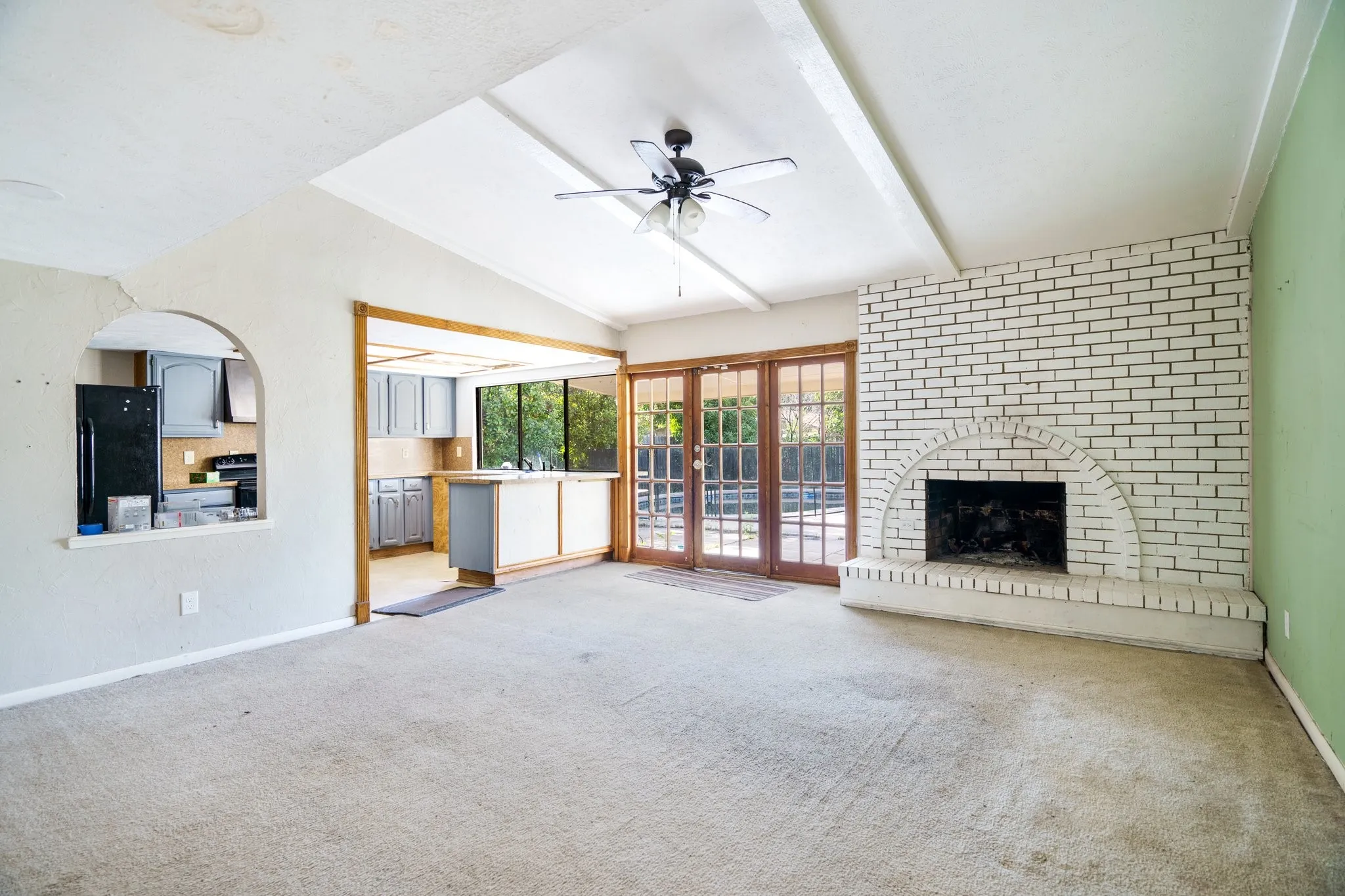 Unfurnished living room with carpet flooring, a ceiling fan, baseboards, and a fireplace
