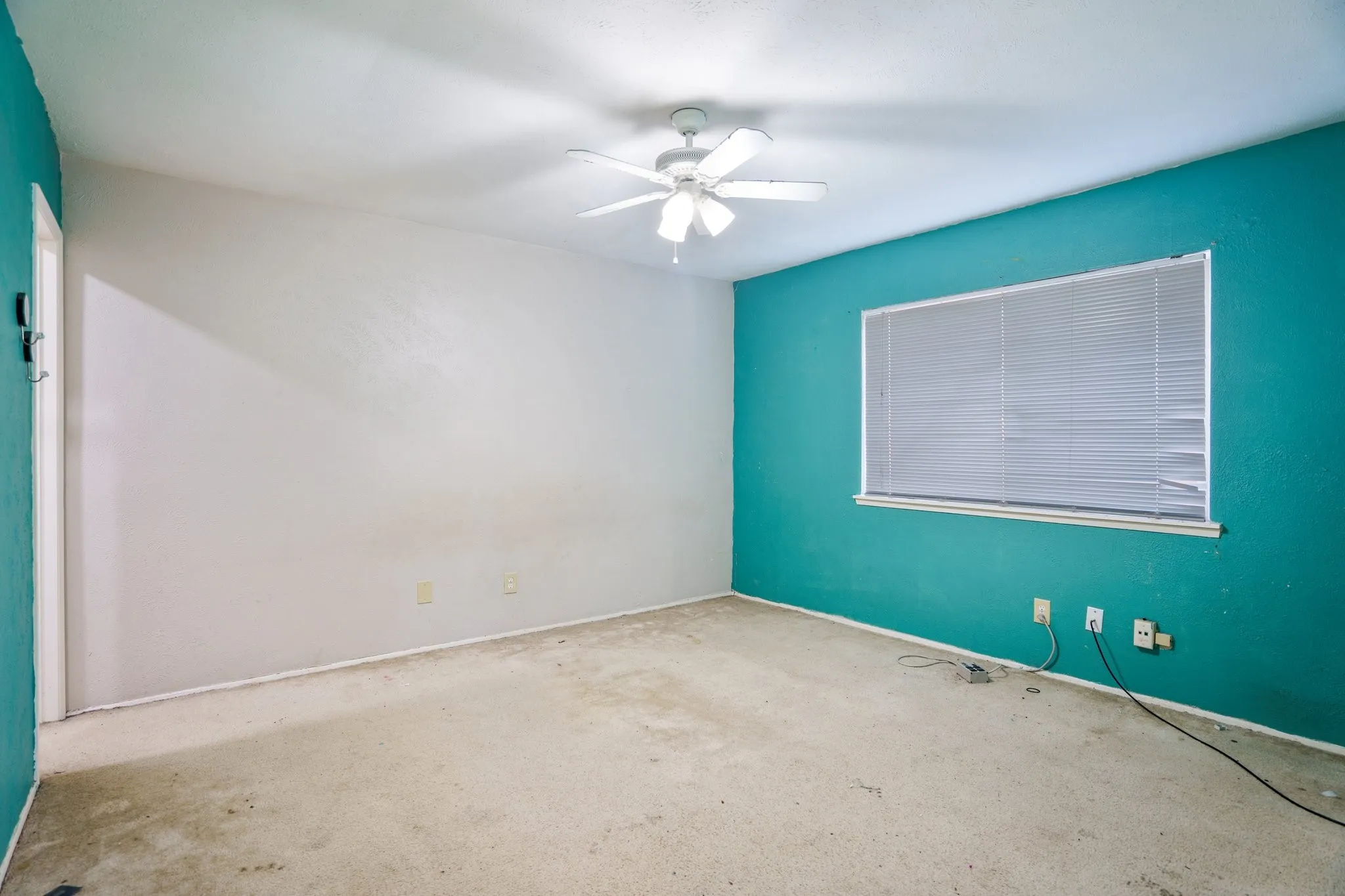 Spare room featuring carpet flooring, a ceiling fan, and baseboards