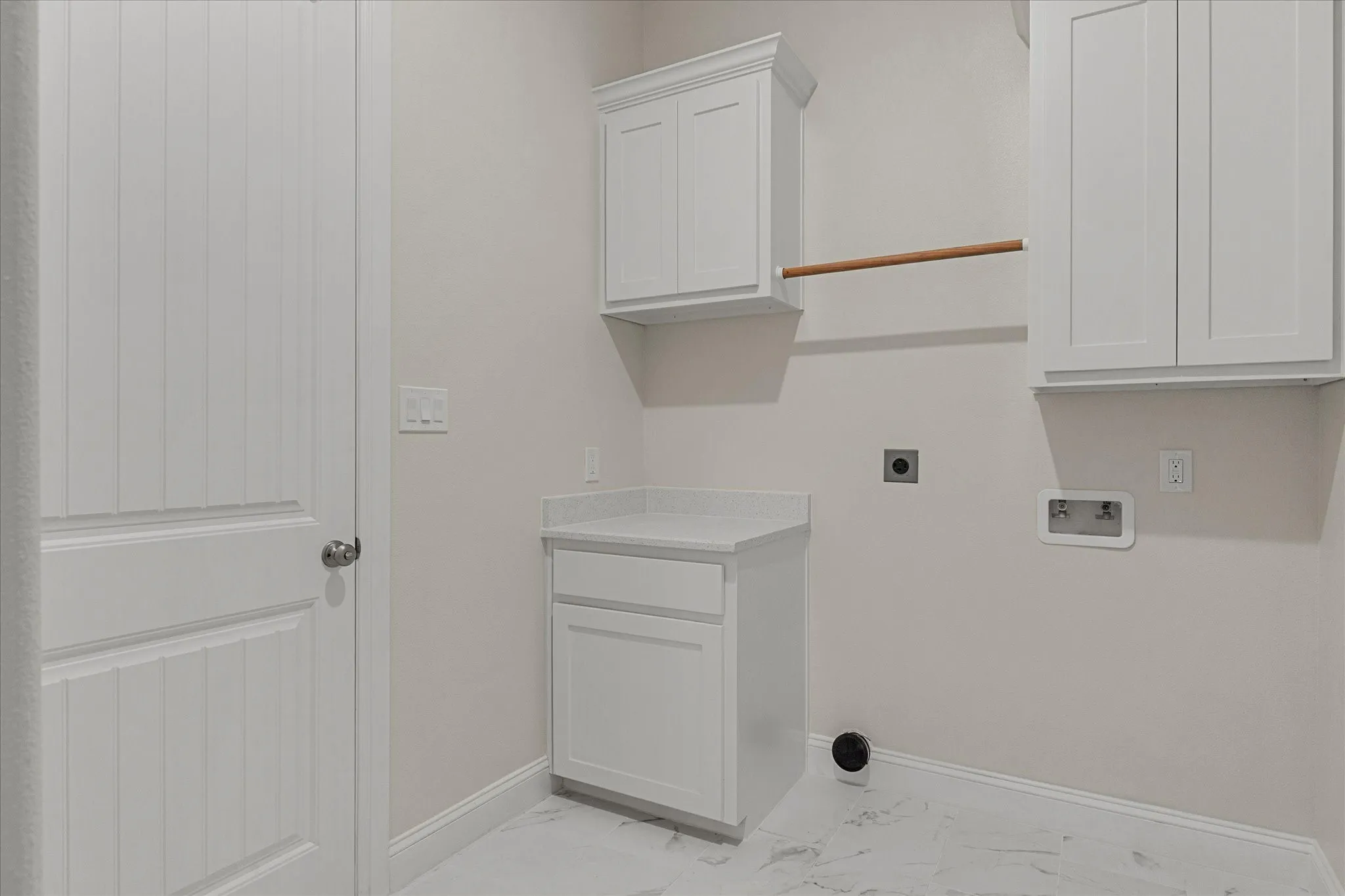 Laundry area featuring light marble finish flooring, electric dryer hookup, washer hookup, and cabinet space