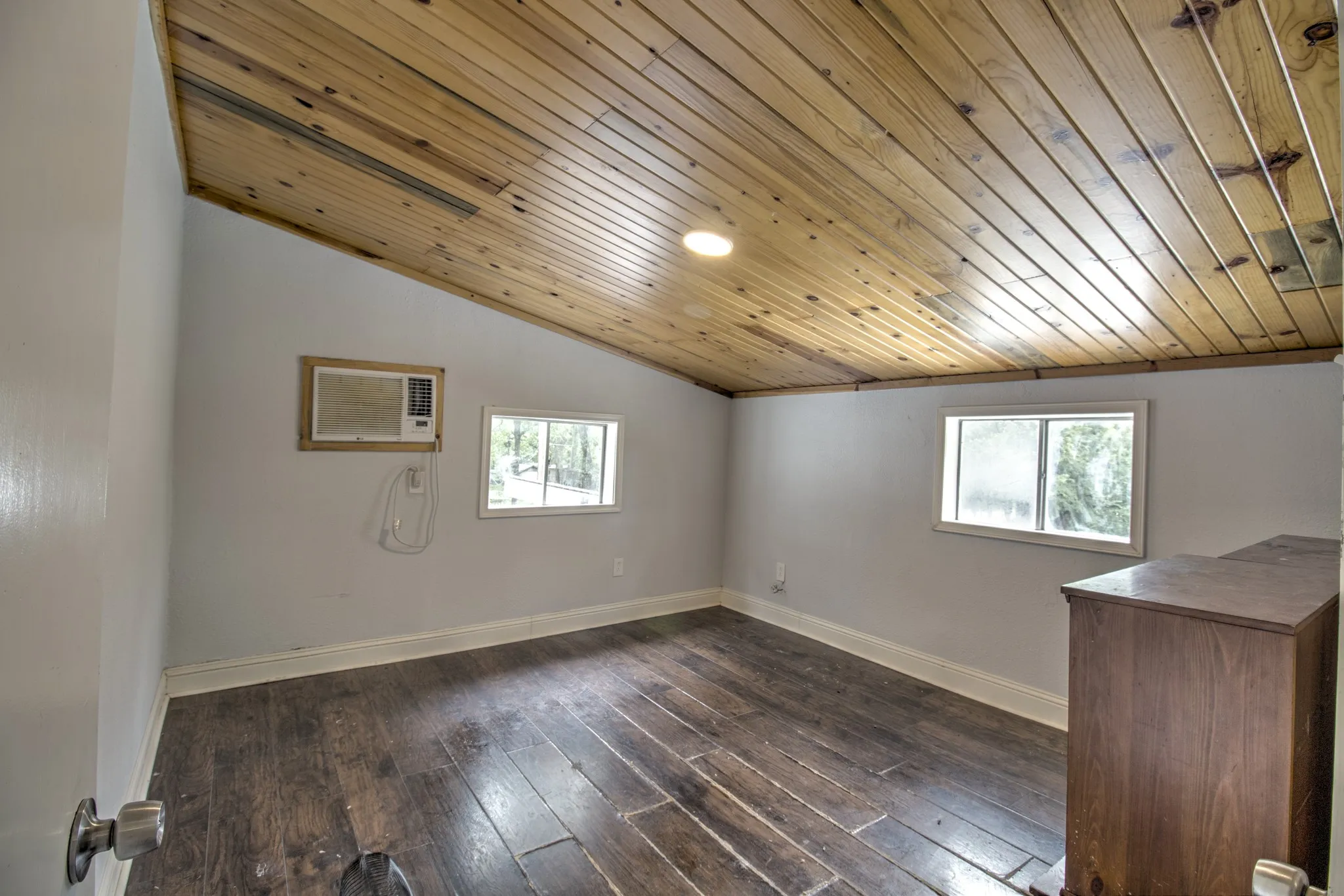 Unfurnished room with wood ceiling, a wall mounted air conditioner, baseboards, dark wood-style flooring, and lofted ceiling