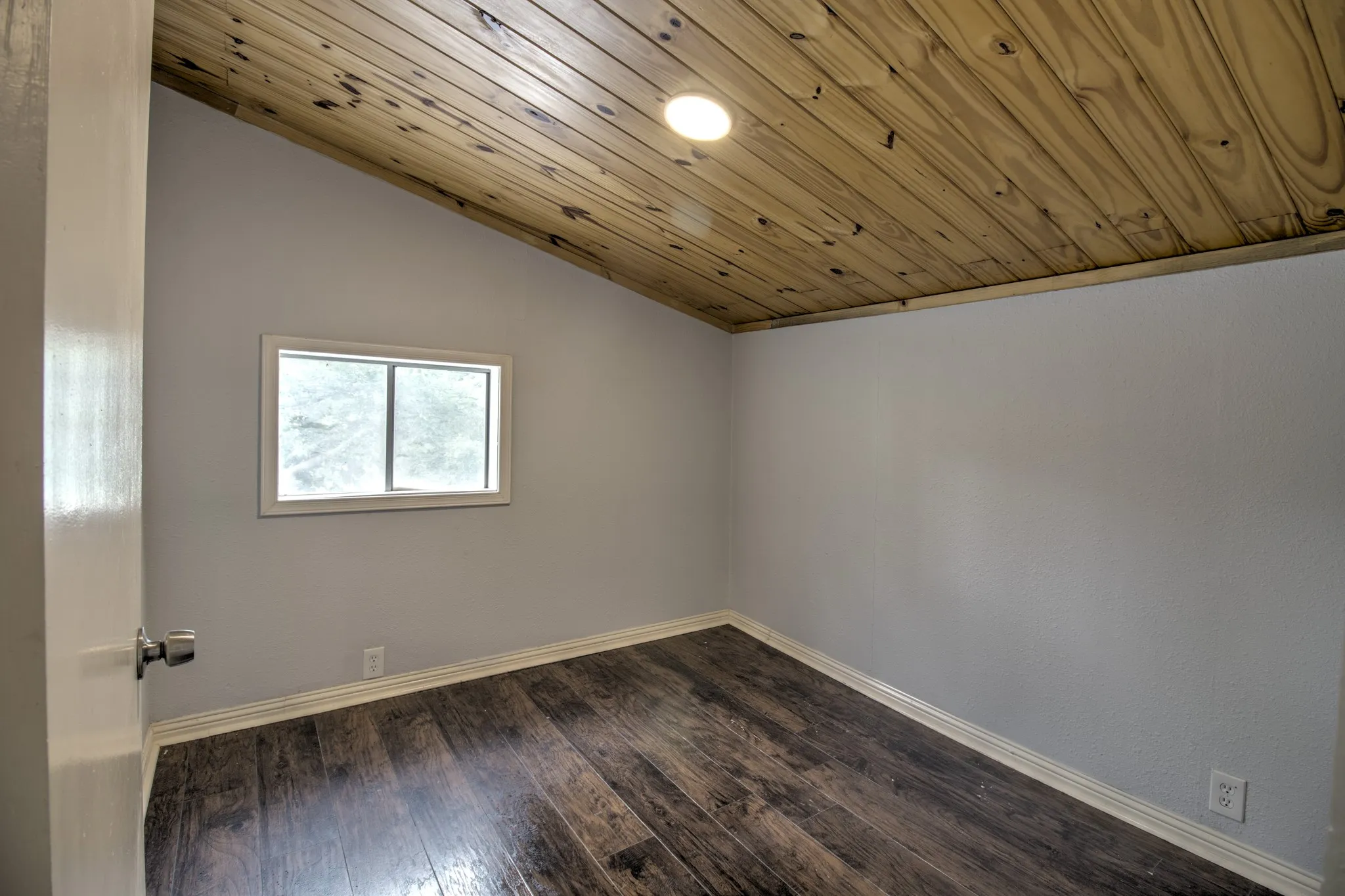 Spare room with lofted ceiling, baseboards, dark wood-style floors, and wooden ceiling