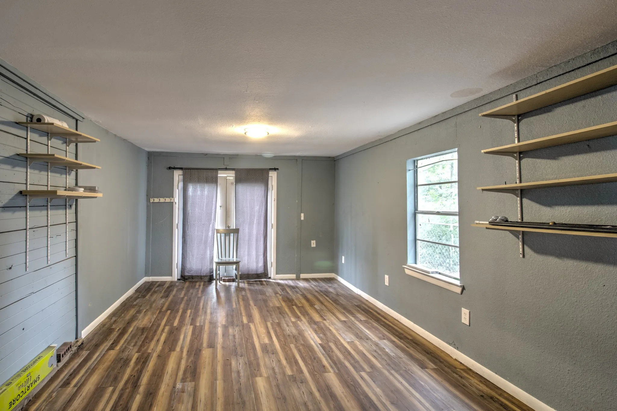 Spare room featuring wood-type flooring and baseboards
