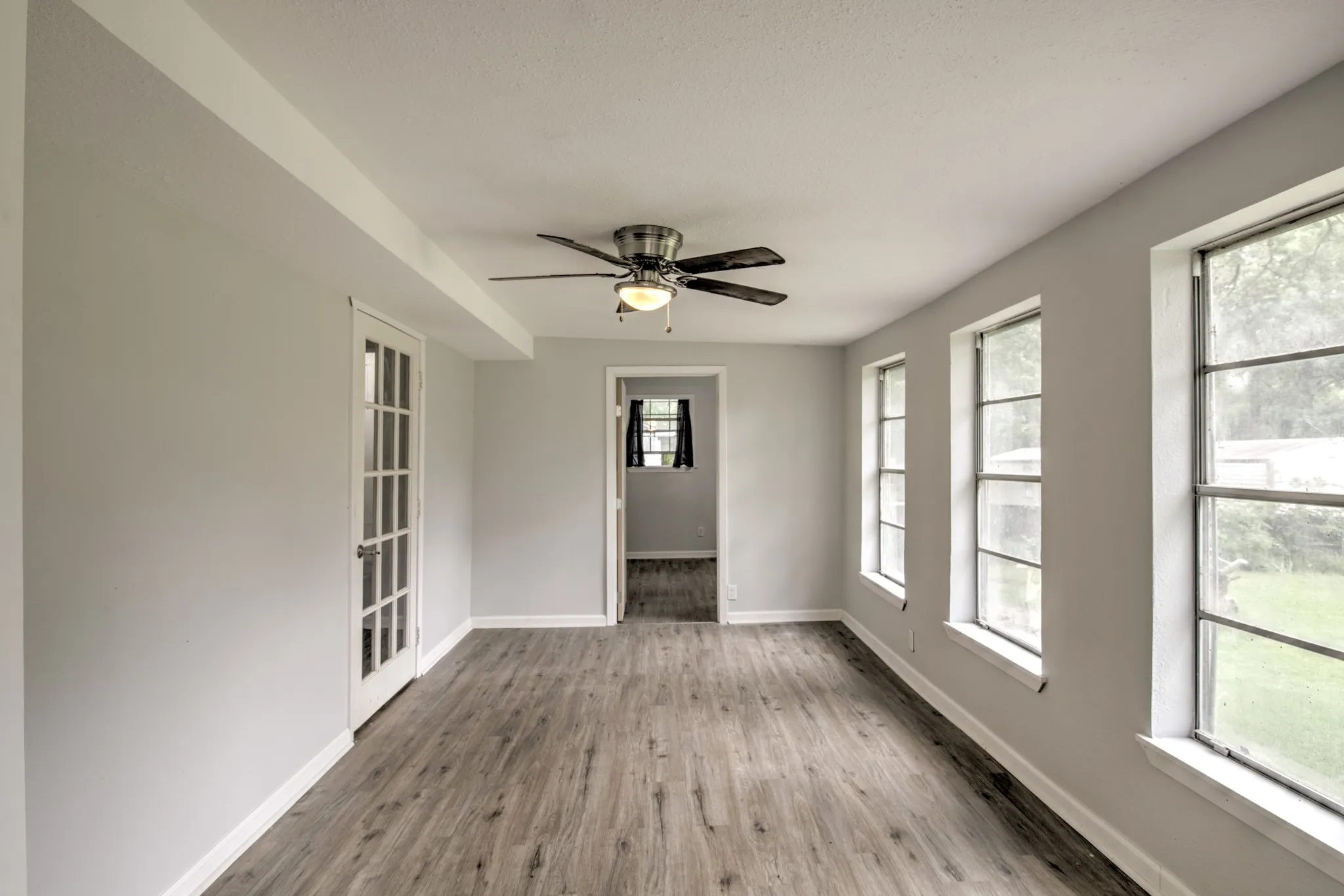 Spare room with wood finished floors, baseboards, and a ceiling fan