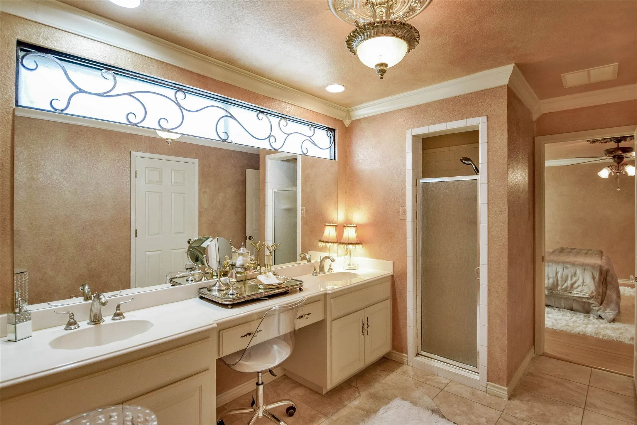Bathroom featuring double vanity, ornamental molding, a shower stall, tile patterned flooring, and ceiling fan