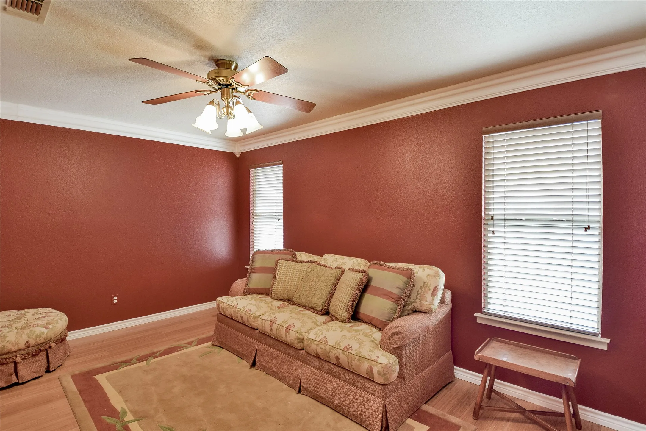 Living area with ornamental molding, ceiling fan, wood finished floors, and baseboards