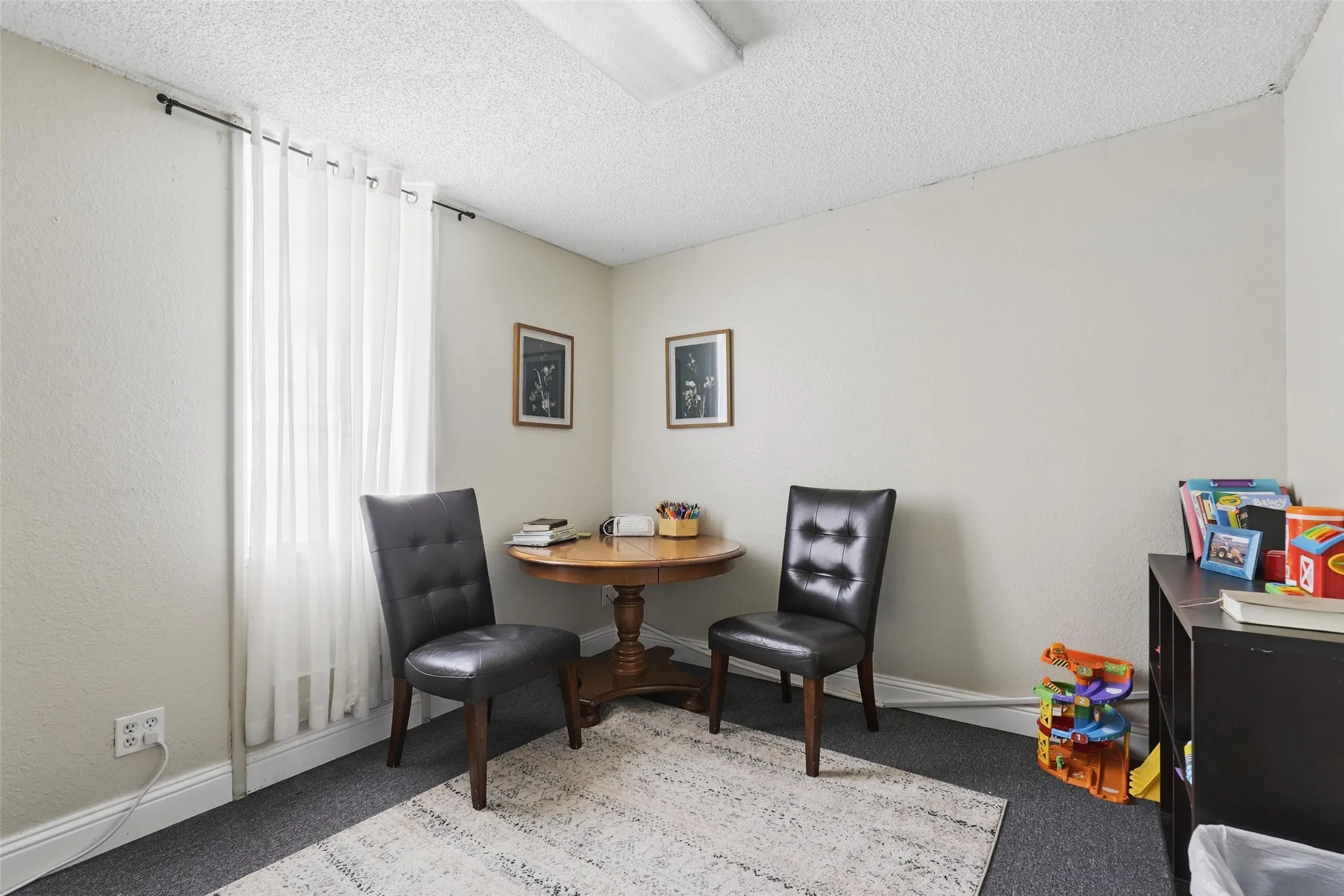 Sitting room with carpet, a textured ceiling, and baseboards
