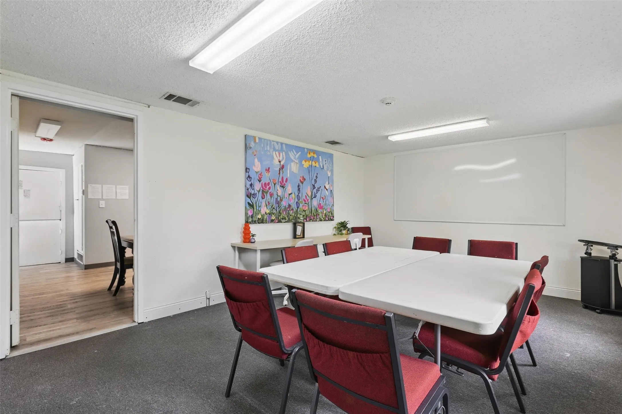 Dining room with a textured ceiling and dark carpet