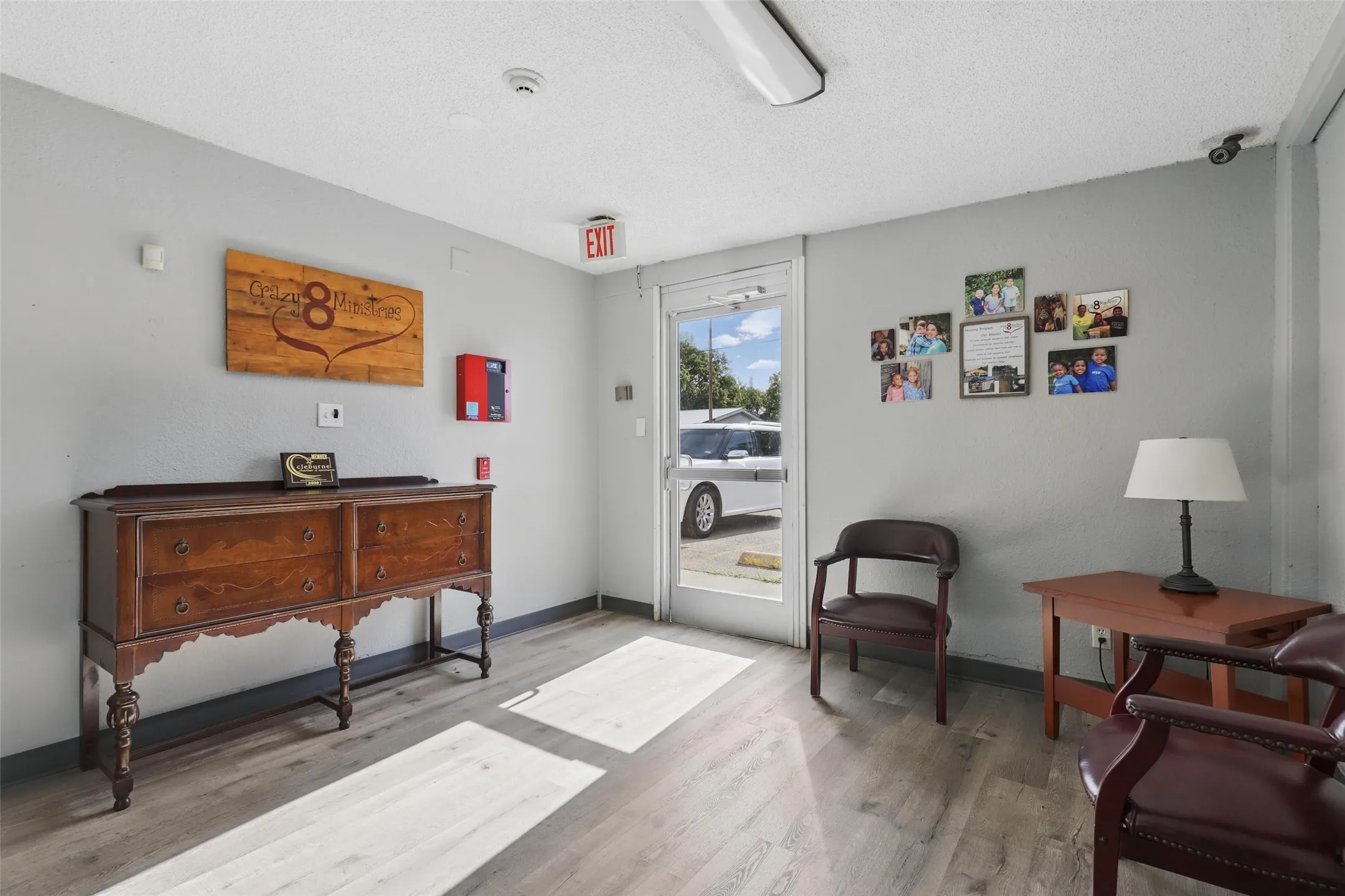 Sitting room with wood finished floors, a textured ceiling, and baseboards