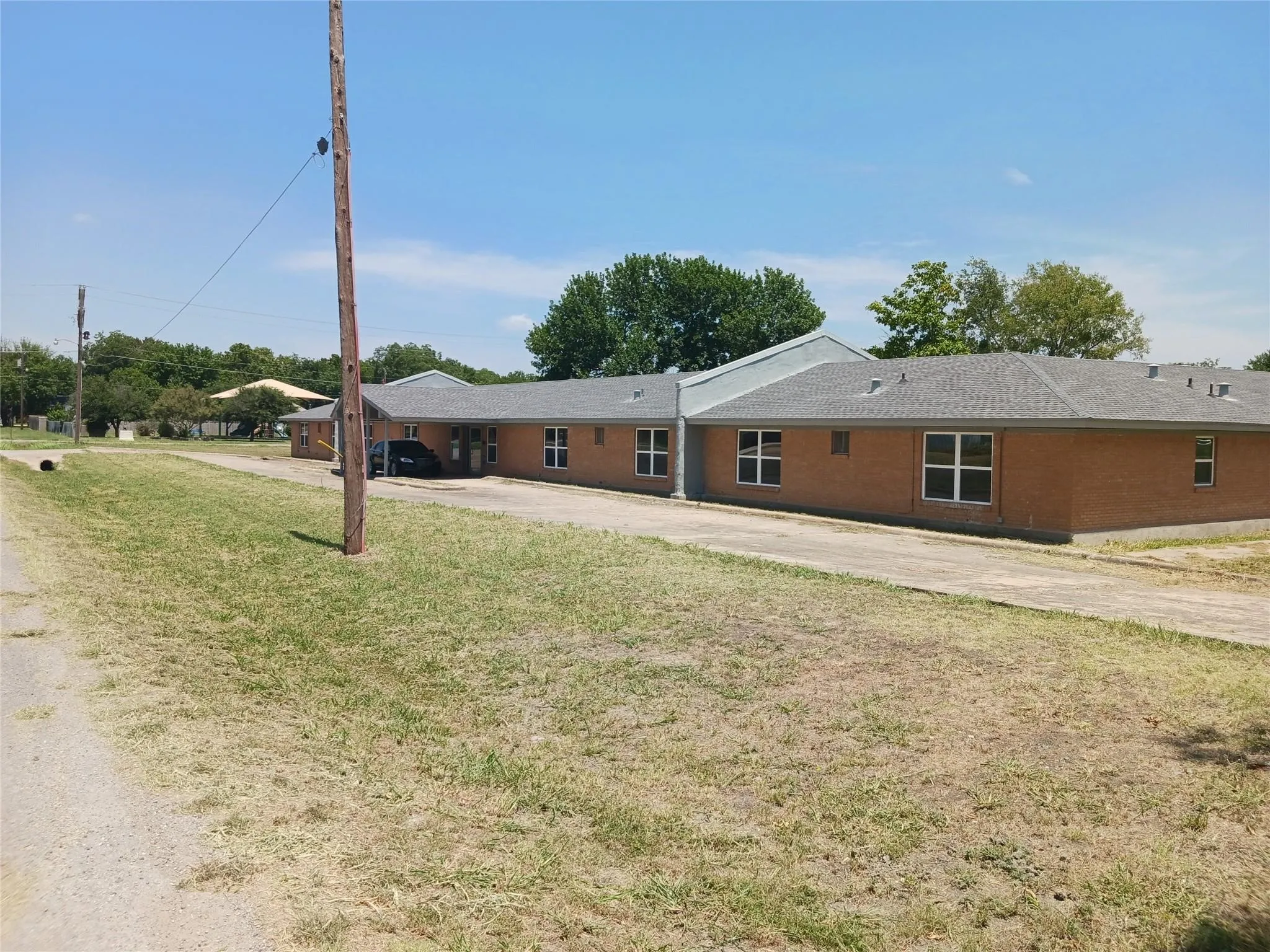 View of front of property with concrete driveway and a front lawn