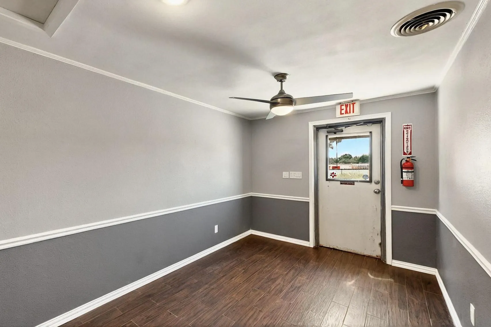 Spare room with dark wood finished floors, ceiling fan, baseboards, and ornamental molding