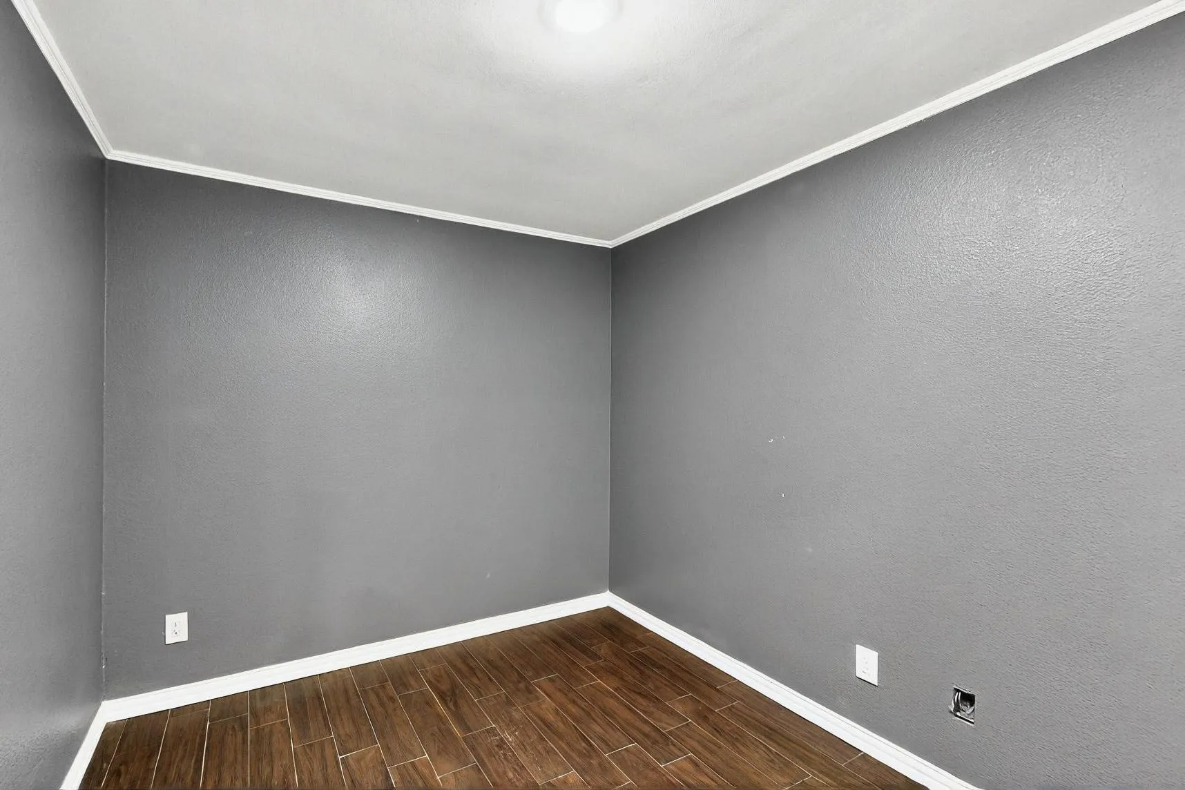 Unfurnished room featuring baseboards, dark wood finished floors, and ornamental molding