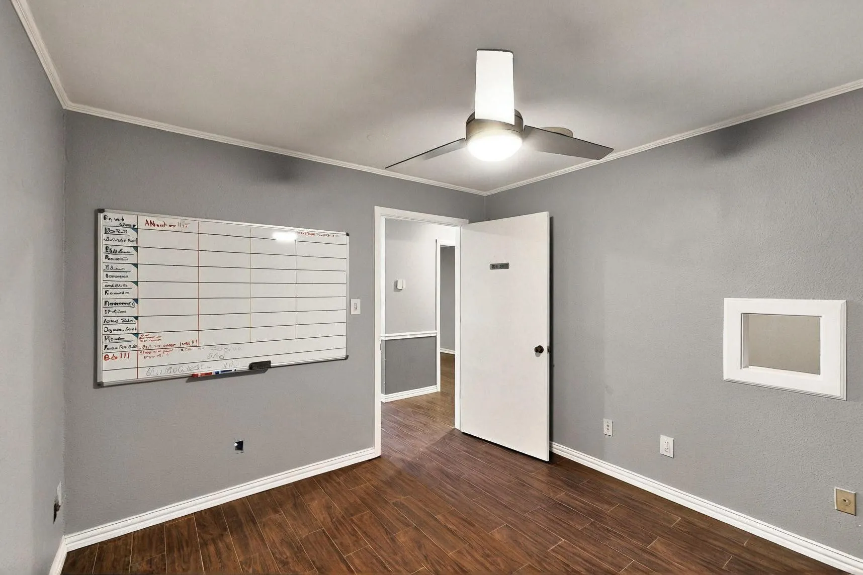 Spare room with ceiling fan, crown molding, dark wood finished floors, and baseboards