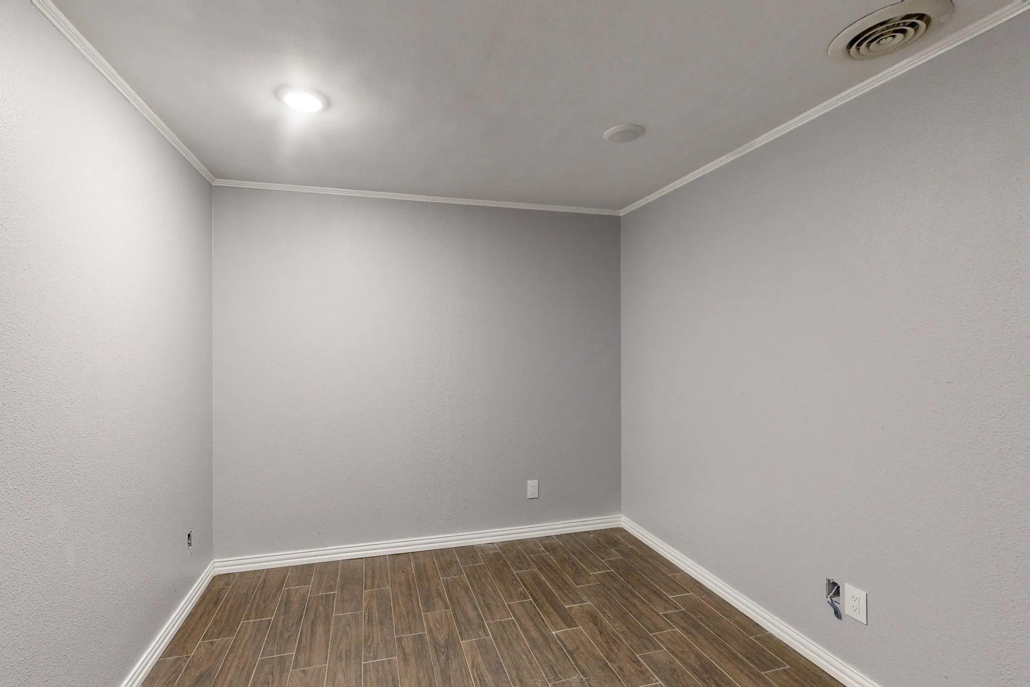 Unfurnished room with wood finish floors, baseboards, and ornamental molding