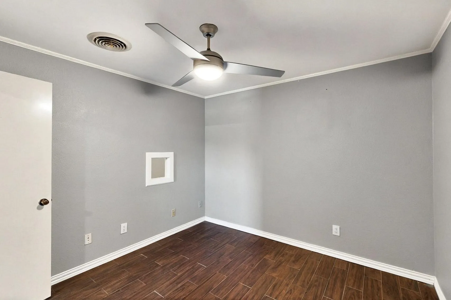 Unfurnished room with wood tiled floors, baseboards, a ceiling fan, and crown molding