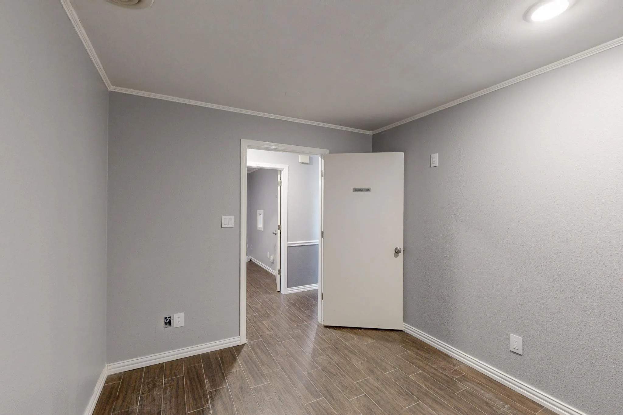 Unfurnished room with wood finished floors, baseboards, and ornamental molding