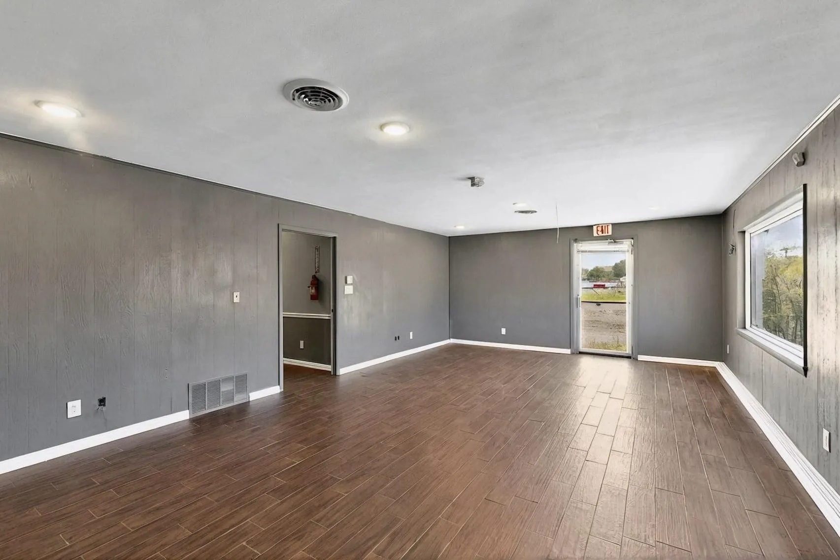 Unfurnished room with dark wood-style floors and baseboards