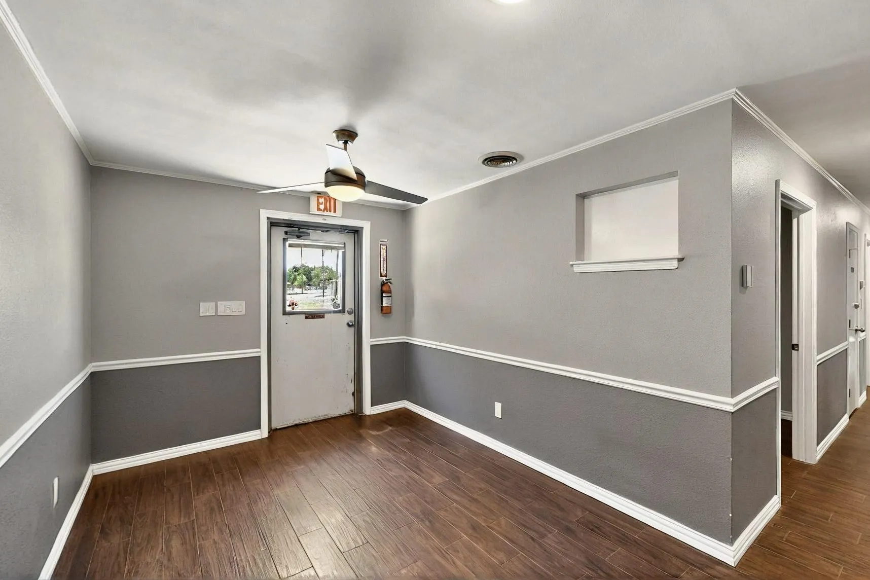 Foyer with crown molding, ceiling fan, wood finished floors, and baseboards