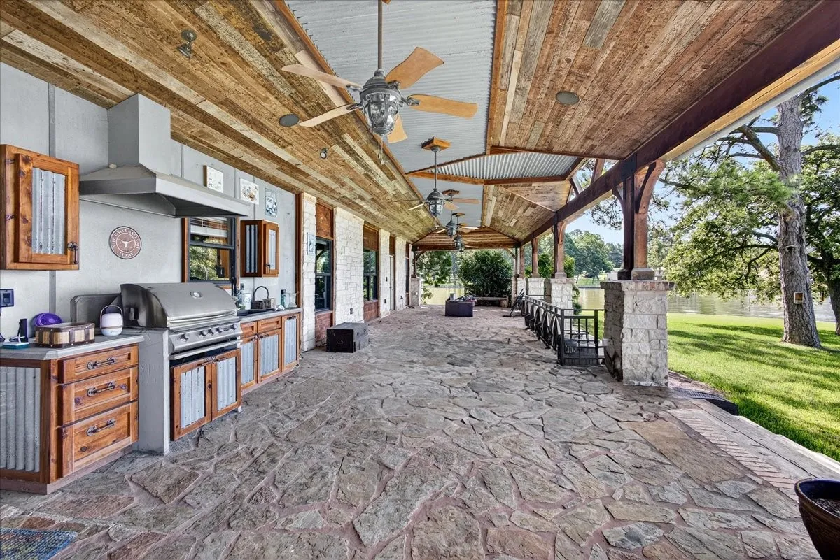 View of patio with area for grilling and a ceiling fan