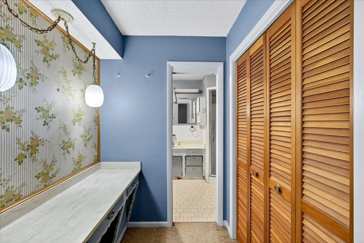 Bathroom with a closet, a textured ceiling, and vanity