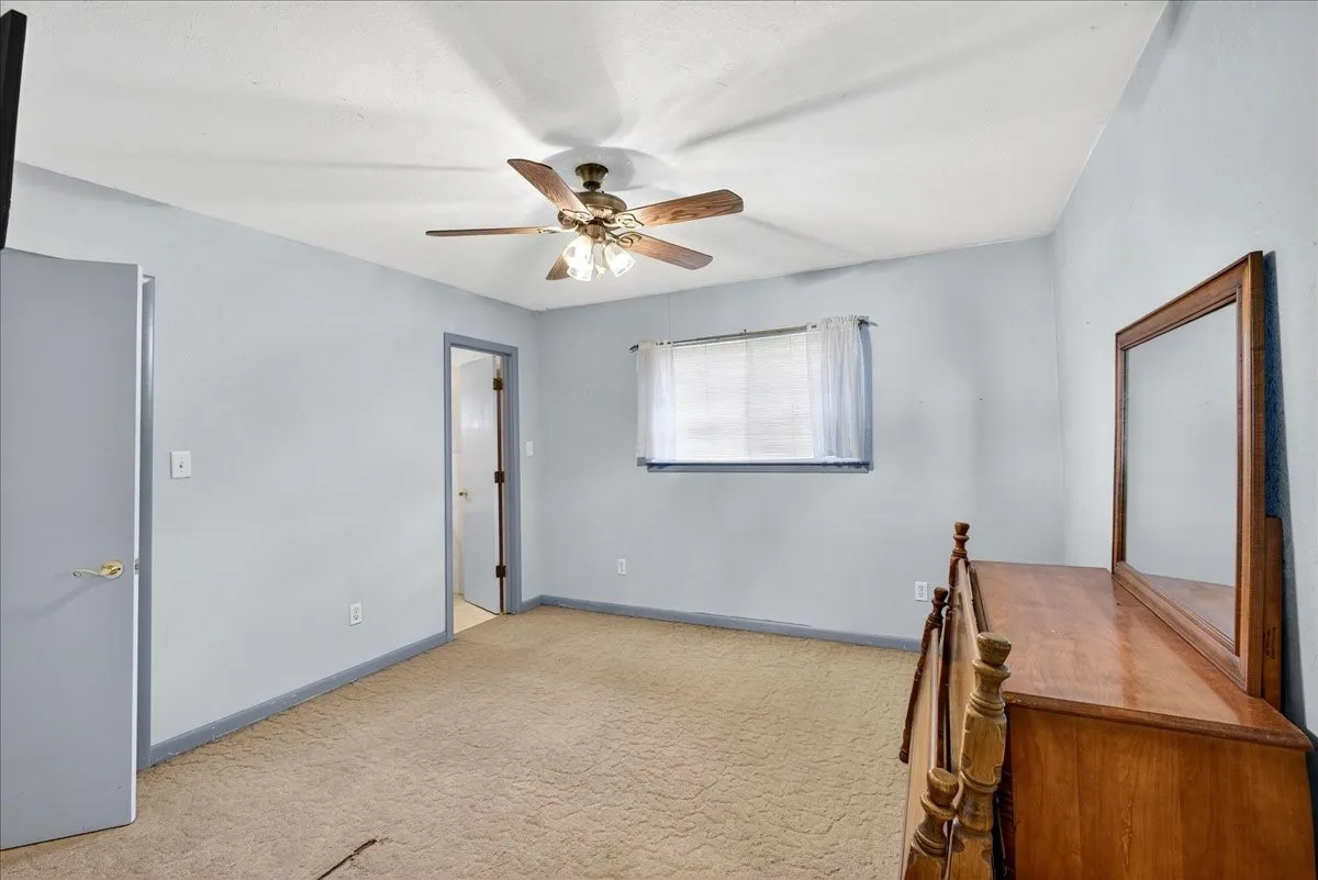 Unfurnished office with a ceiling fan and carpet