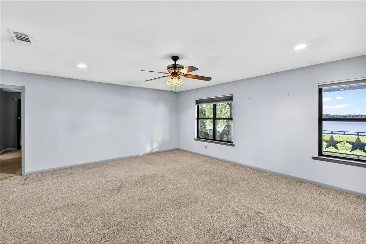 Carpeted spare room featuring ceiling fan and recessed lighting