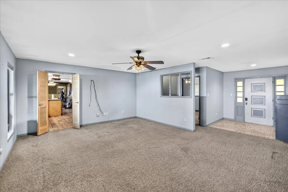 Unfurnished living room featuring carpet floors, a ceiling fan, and recessed lighting