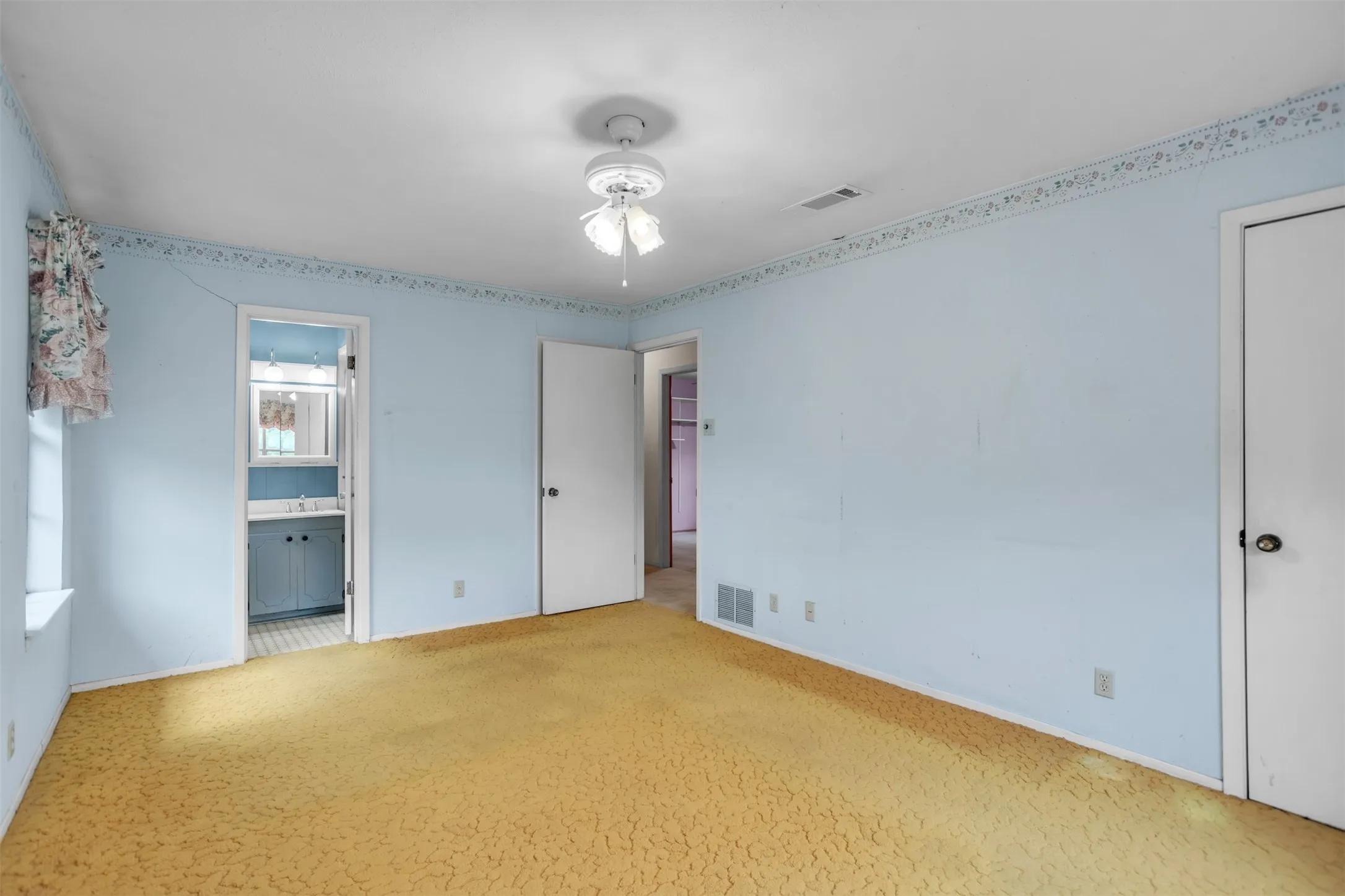 Unfurnished bedroom with carpet floors, ensuite bathroom, a sink, and baseboards