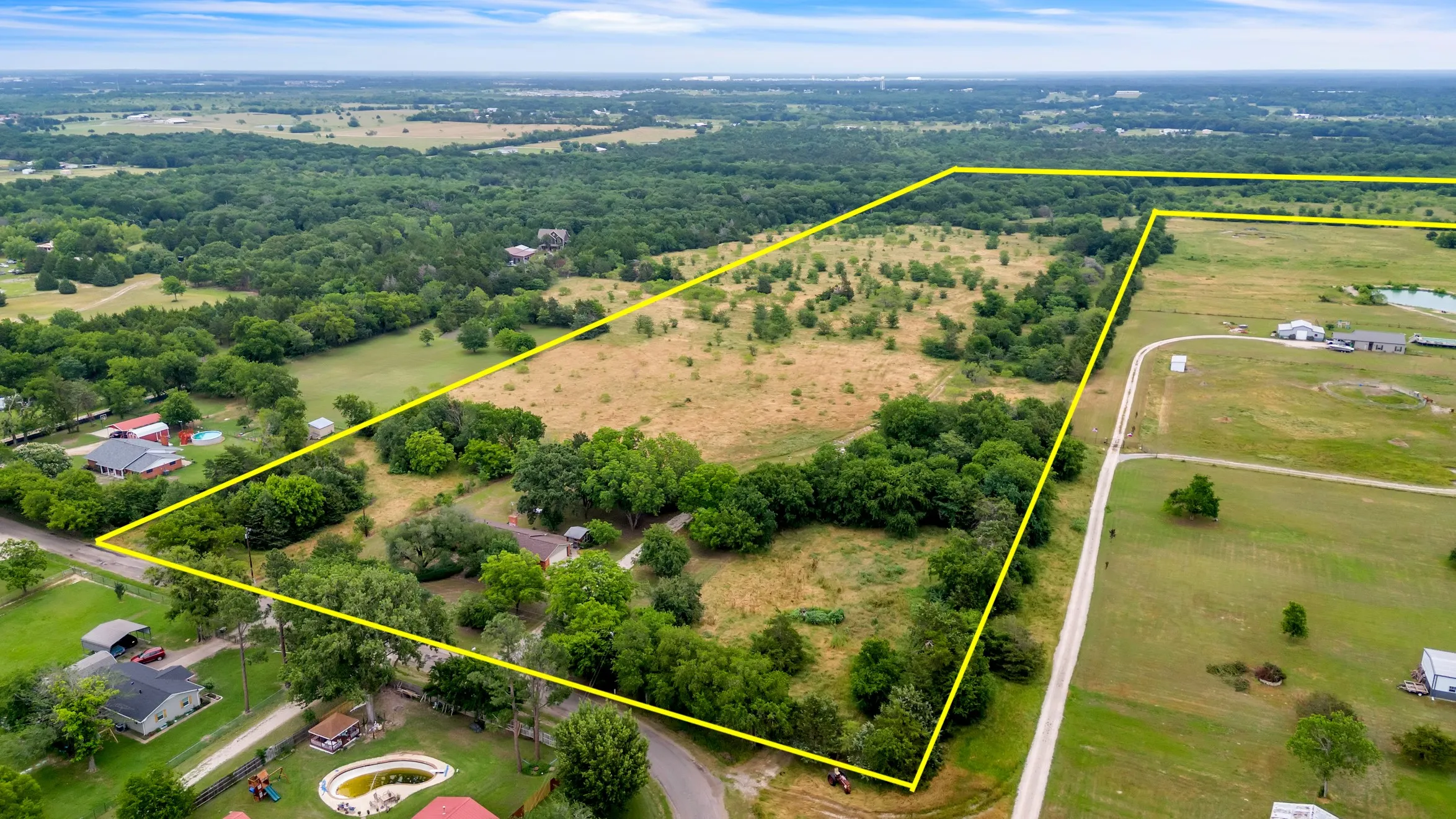 Aerial view of sparsely populated area featuring property parcel outlined