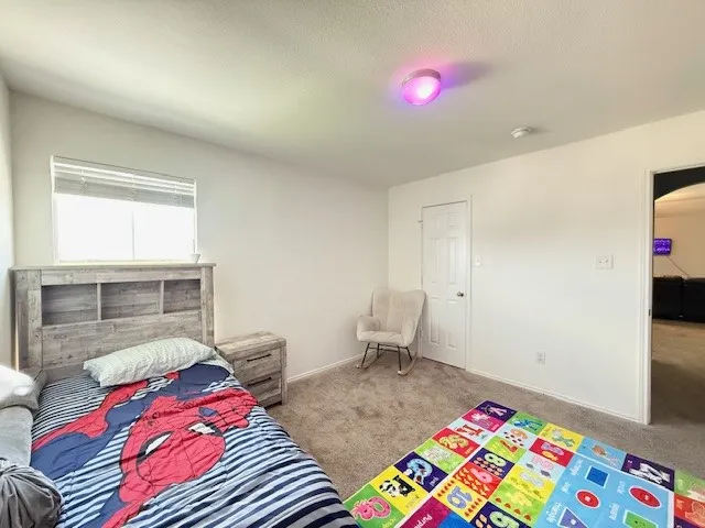 Carpeted bedroom featuring baseboards