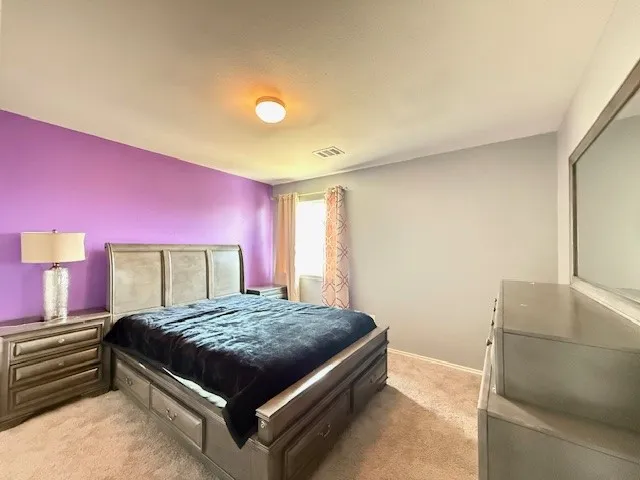 Bedroom featuring light colored carpet and baseboards