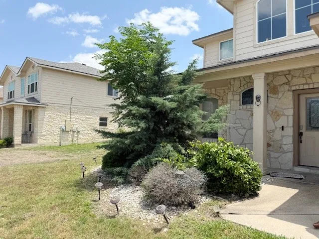 Property entrance with stone siding and a yard