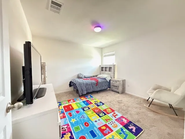 Carpeted bedroom featuring baseboards