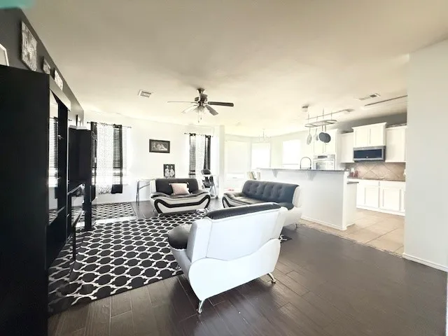 Living area with ceiling fan and light wood-style floors